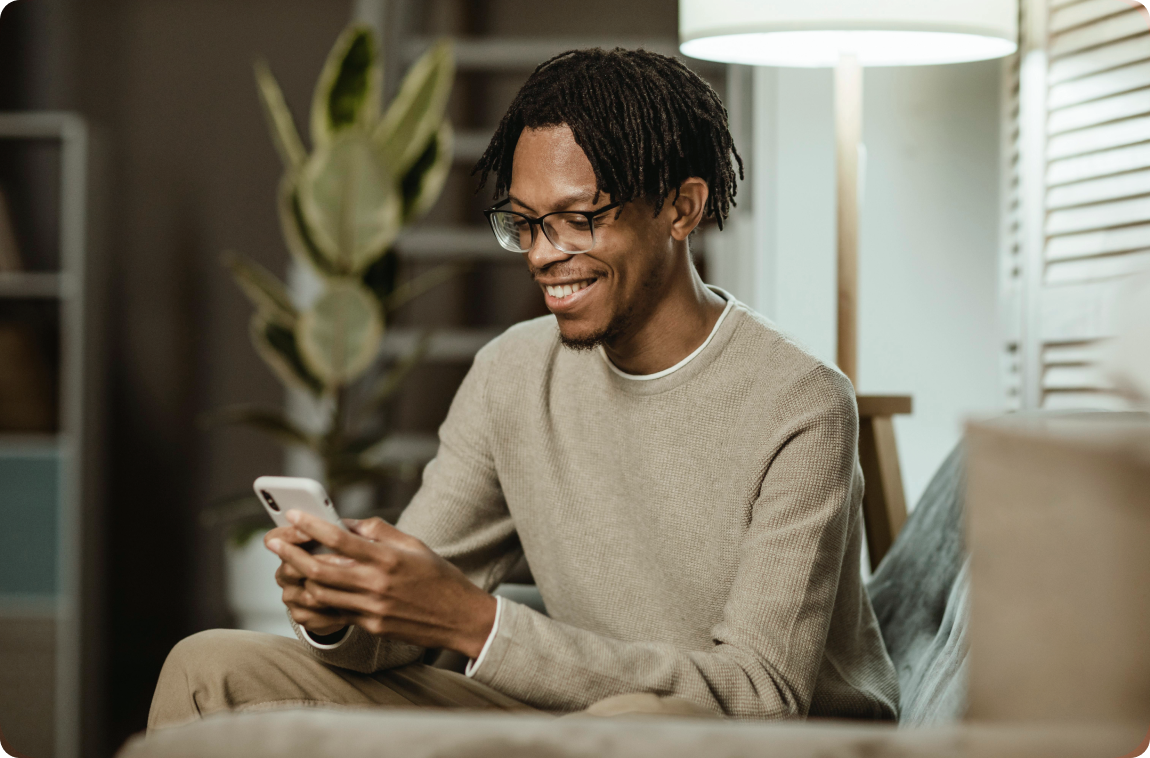 homem negro sorrindo mexendo no celular